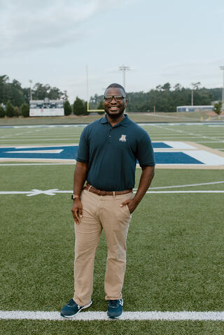 Mr. Ladson standing at the end of the football field